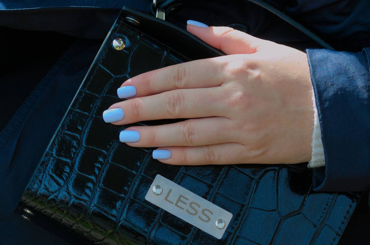 Flawless manicured hands holding a clipper with light