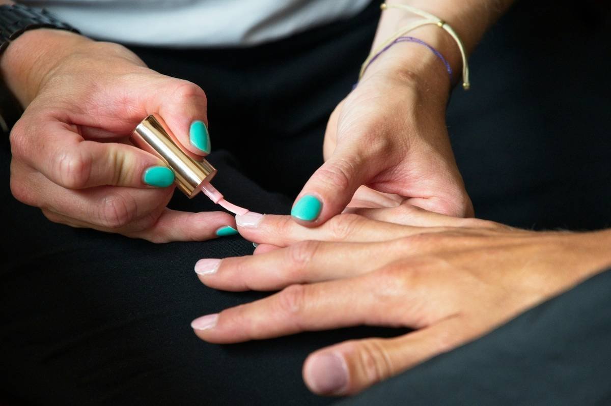 A nail artist demonstrating perfect technique with precision tip clippers.