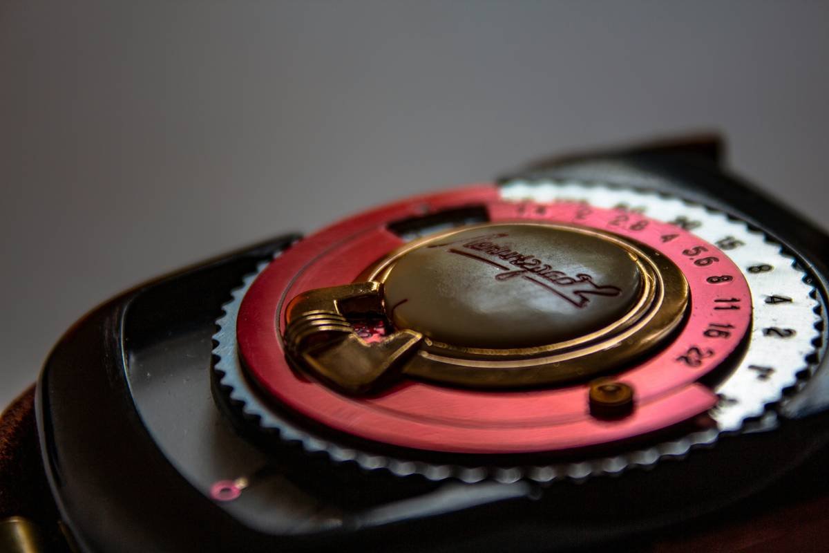 a close up of a watch with a pink and black case
