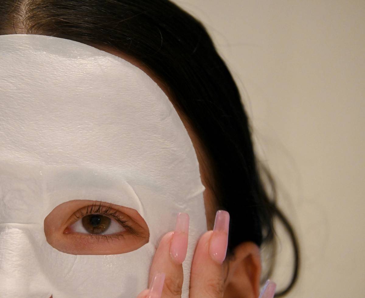 a woman with a white mask covering her face