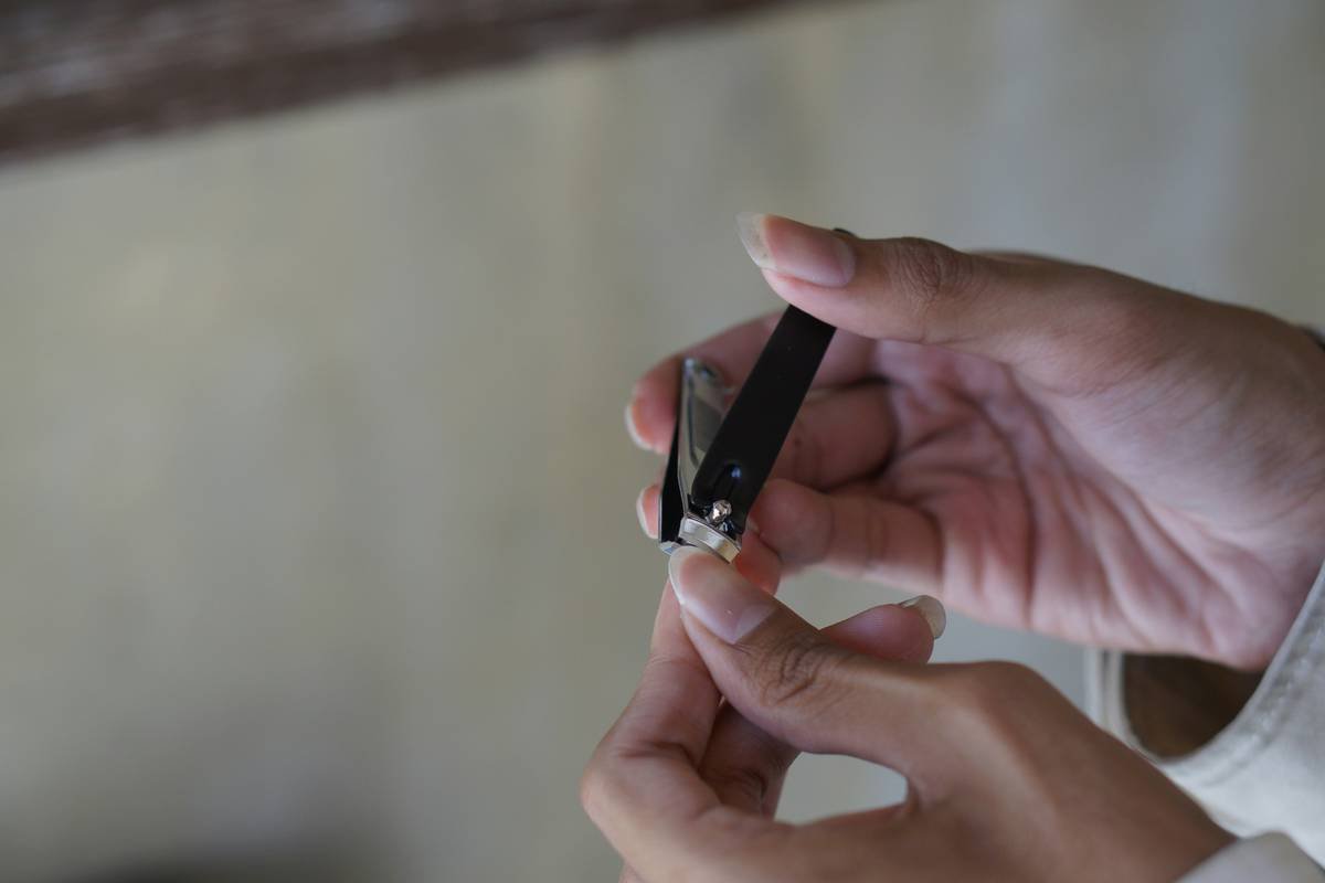Close up of a man cutting his fingernail using nail clipper